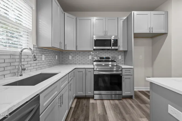 a kitchen with stainless steel appliances granite countertop a sink stove and microwave