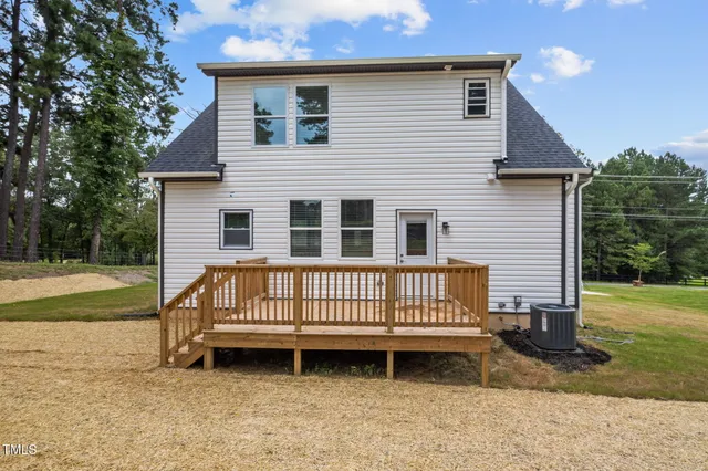 a view of a house with backyard and a tree