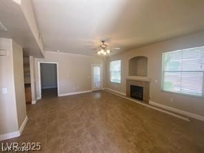 10550 West Alexander Road, Unit 1155 Las Vegas, NV 89129 - Photo 2 of 7 Unfurnished living room with ceiling fan, plenty of natural light, and a fireplace with raised hearth