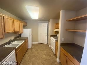 10550 West Alexander Road, Unit 1155 Las Vegas, NV 89129 - Photo 5 of 7 Kitchen with dark countertops, white appliances, and wood finish cabinets