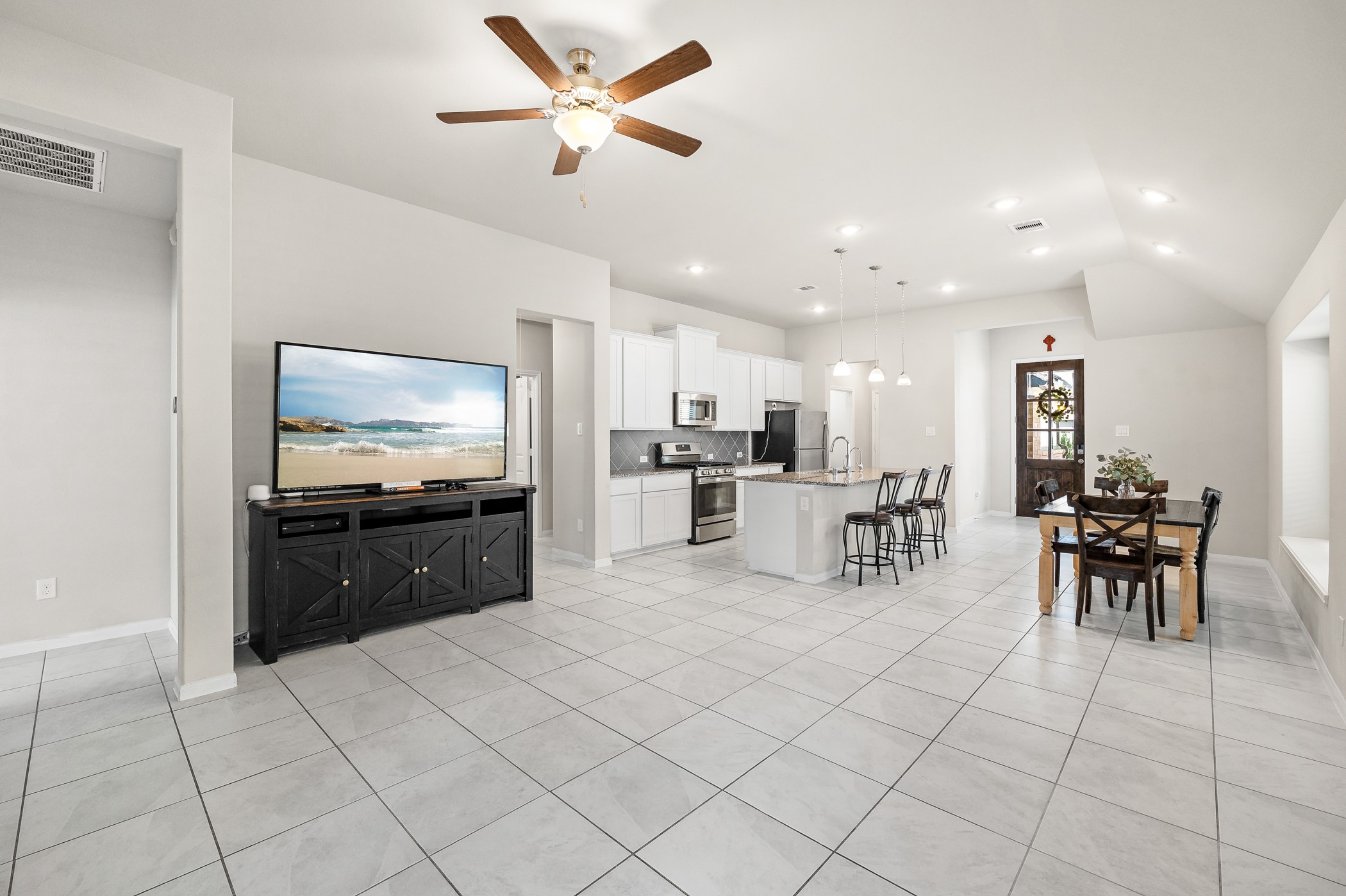 3722 Amoroso Drive Rosharon, TX 77583 - Photo 12 of 27 a kitchen with stainless steel appliances kitchen island granite countertop a refrigerator a stove a microwave oven with white cabinets and chairs