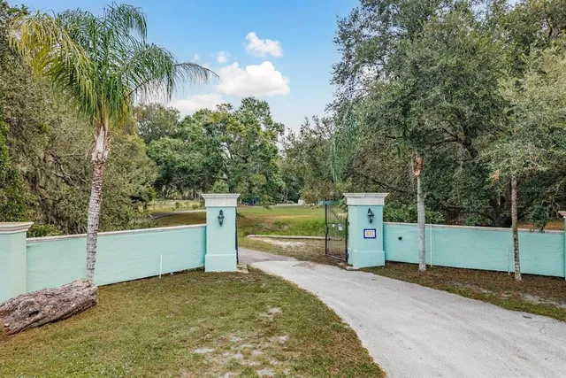 an aerial view of residential houses with outdoor space and trees