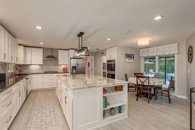 a kitchen with granite countertop white cabinets and white appliances