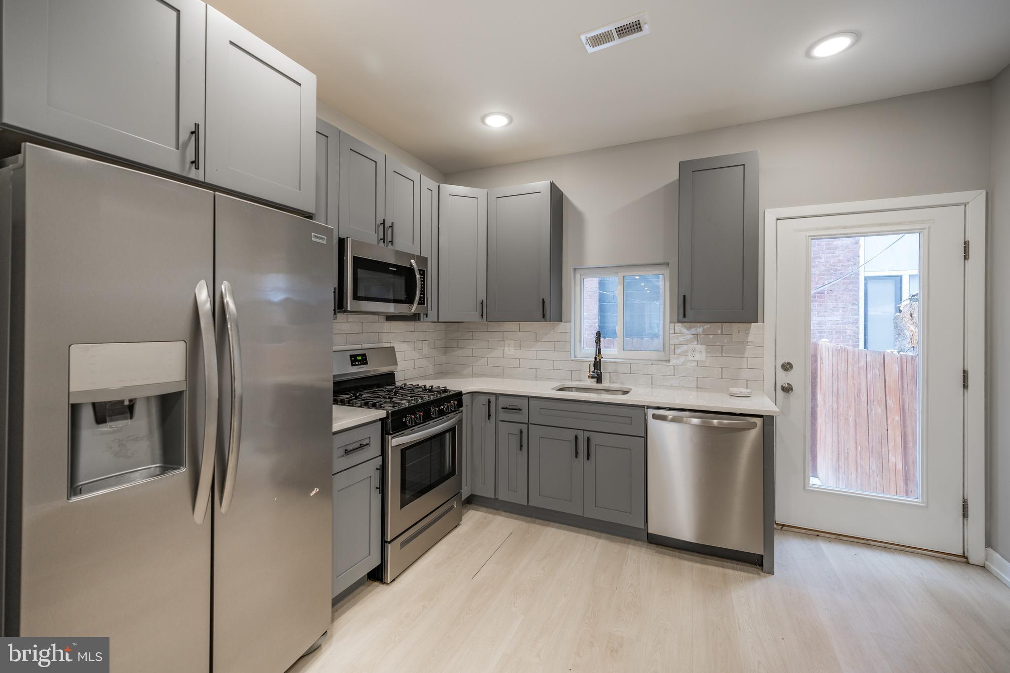 2428 Jasper Street, Unit A Philadelphia, PA 19125 - Photo 2 of 26 a kitchen with stainless steel appliances granite countertop a stove a sink and a refrigerator