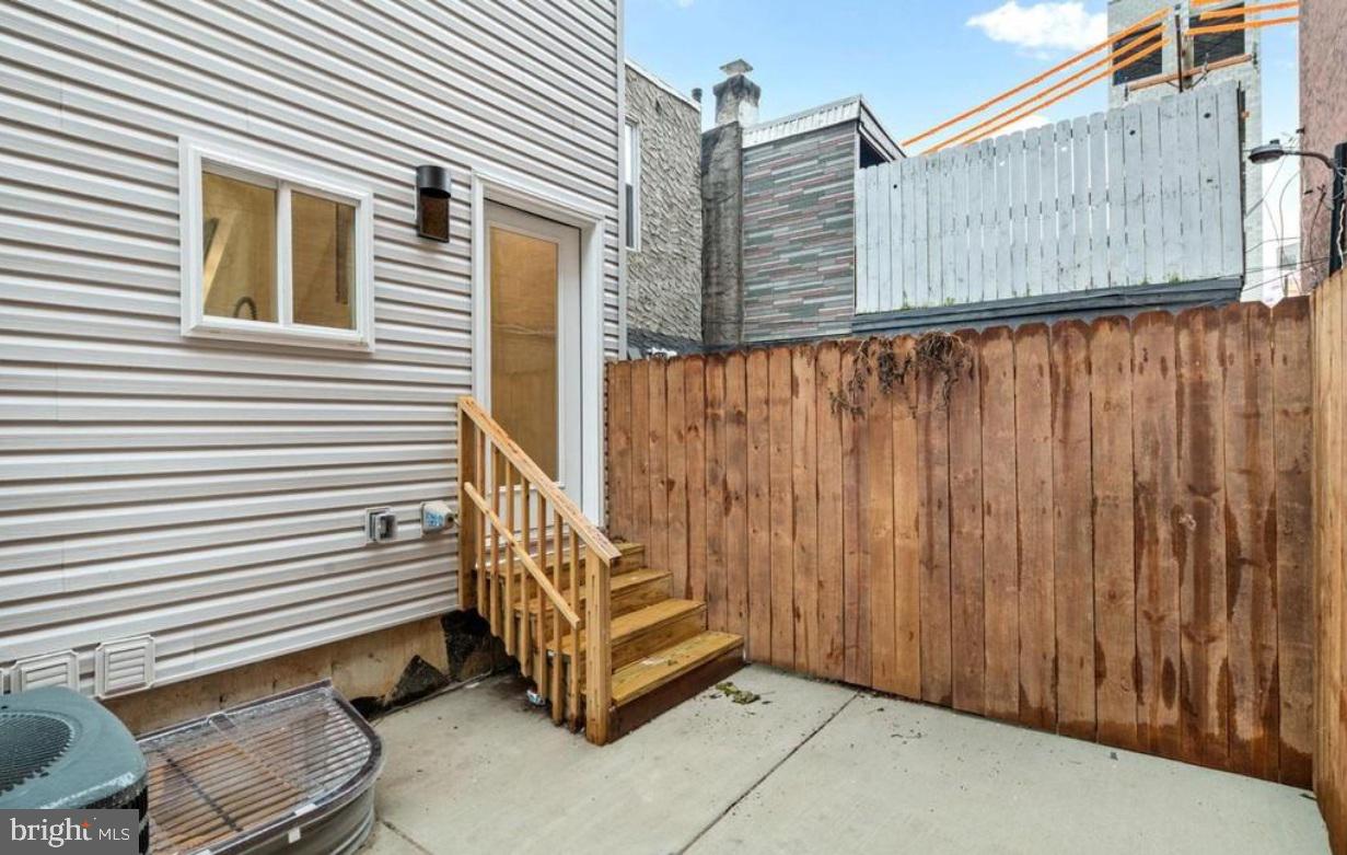 2428 Jasper Street, Unit A Philadelphia, PA 19125 - Photo 24 of 26 a backyard of a house with wooden fence and a large tree