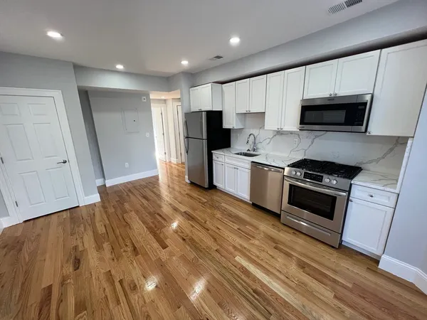 a kitchen with stainless steel appliances a stove a sink and a refrigerator