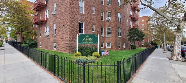 a view of a brick house with wooden fence