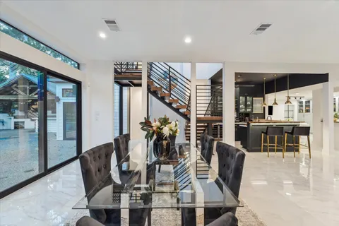 a dining room with furniture one side view and wooden floor