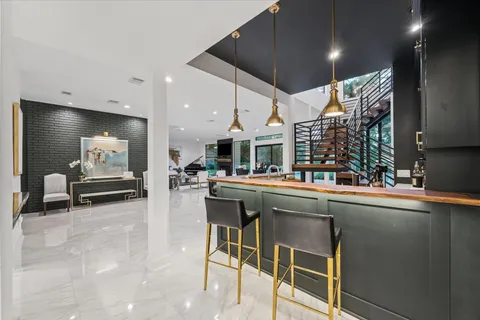 a dining room with stainless steel appliances kitchen island granite countertop a dining table chairs and view kitchen