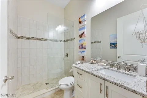 a bathroom with a granite countertop sink toilet and shower
