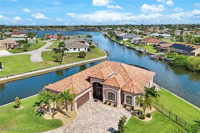 an aerial view of residential houses with outdoor space and lake view