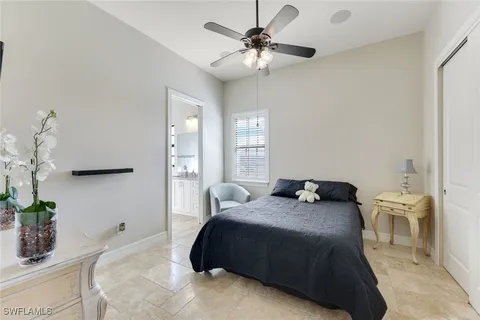 a bedroom with a bed chandelier and a window