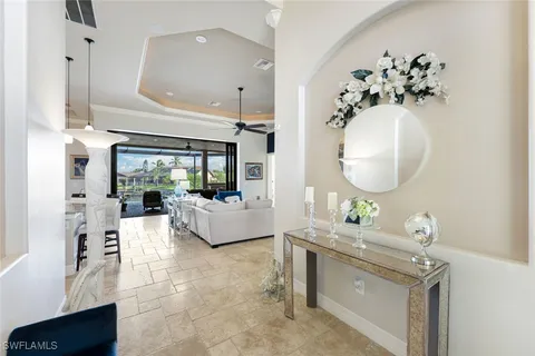a living room with furniture chandelier and a mirror