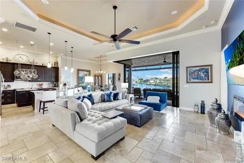 a living room with furniture kitchen view and a large window
