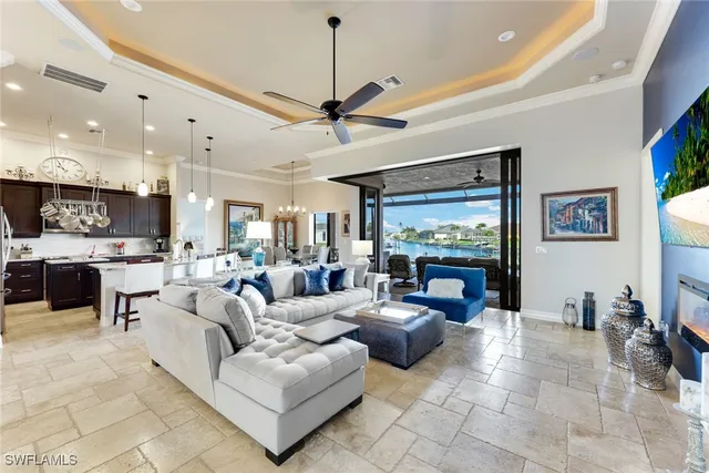 a living room with furniture kitchen view and a large window
