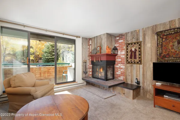 a living room with furniture a flat screen tv and a fireplace