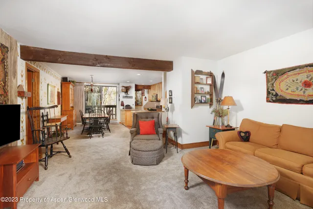 a living room with furniture a rug and white walls