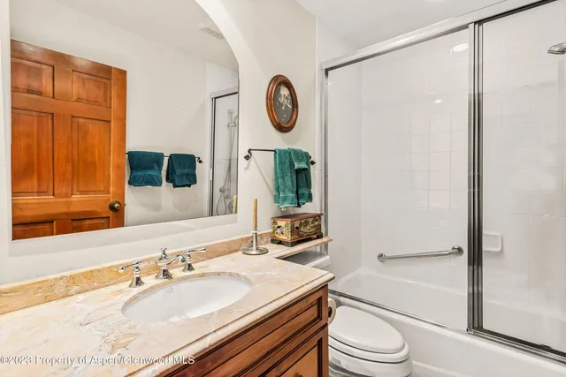 a bathroom with a granite countertop sink toilet a mirror and shower