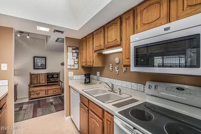 a kitchen with granite countertop a sink stove and cabinets
