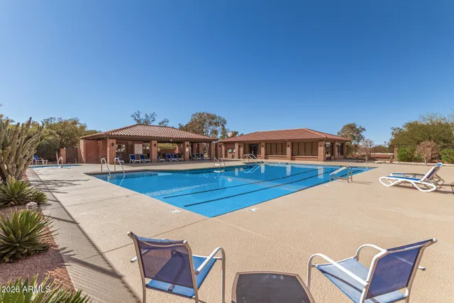 a view of a tall building with swimming pool in front of it