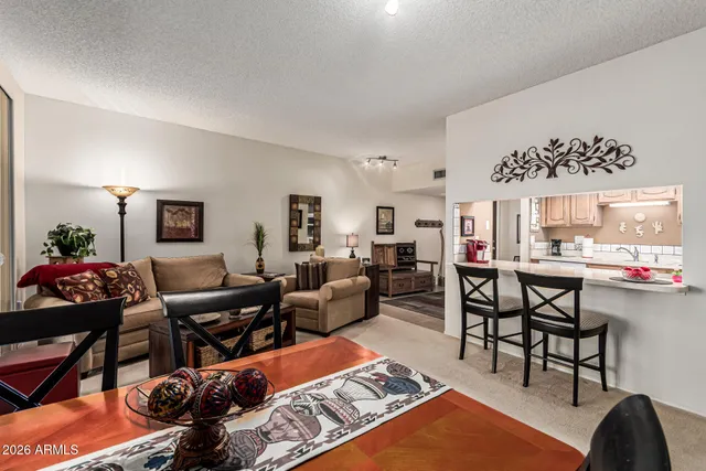 a living room with furniture a rug and a painting on the wall