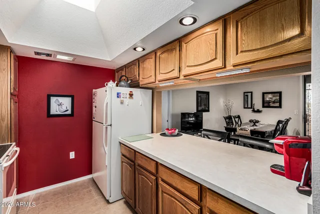 a view of a kitchen with fridge and workspace