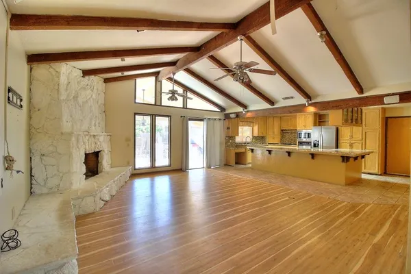 a view of a living room with stainless steel appliances kitchen island granite countertop a large window