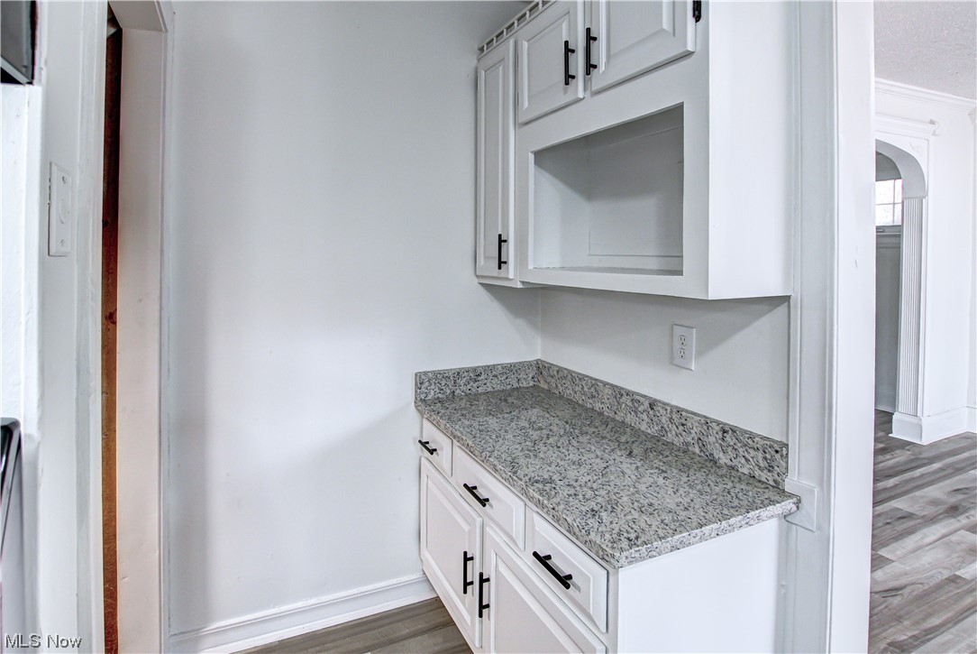 4764 Rockwood Road Cleveland, OH 44125 - Photo 6 of 35 Kitchen featuring white cabinets, light stone countertops, and hardwood / wood-style flooring