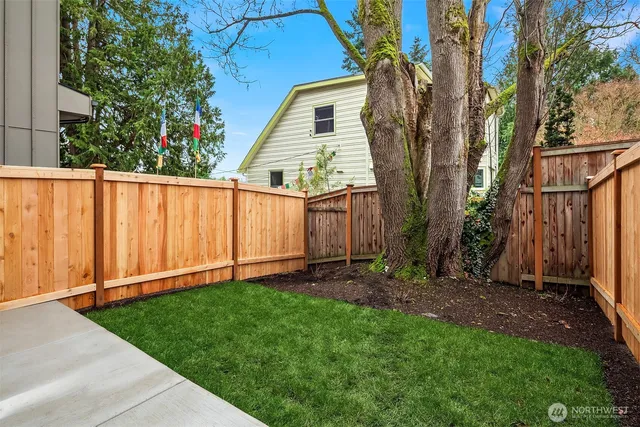 a view of a backyard with wooden fence