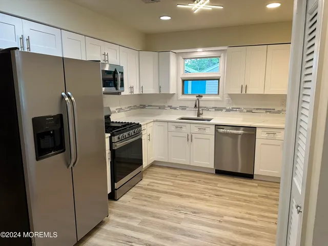 a kitchen with stainless steel appliances a refrigerator sink and cabinets