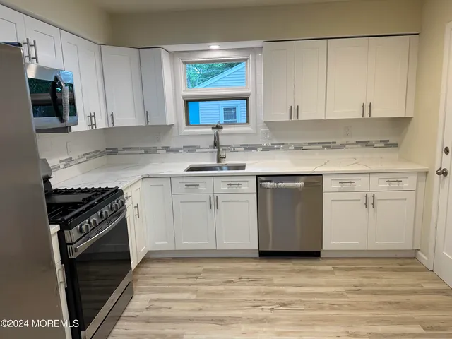 a kitchen with a sink stove and cabinets
