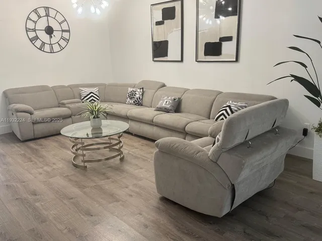 a living room with furniture and wooden floor