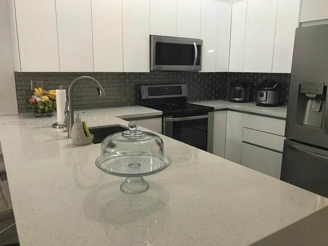 a kitchen with a sink a stove and cabinets