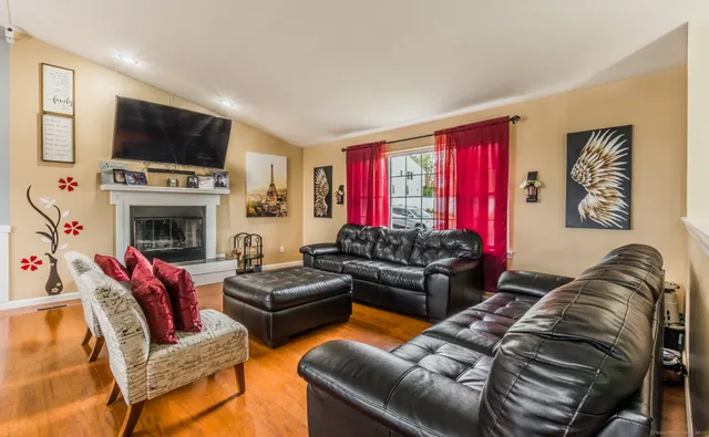 a living room with furniture a flat screen tv and a fireplace