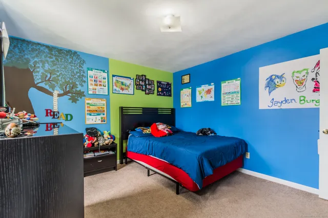 a bedroom with bed and a wall painting