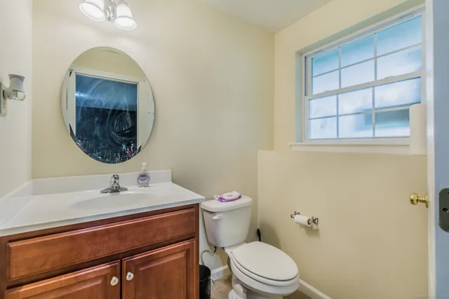 a bathroom with a sink a toilet and a mirror