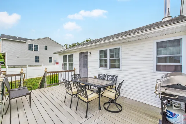 a view of a patio with table and chairs with wooden floor and fence