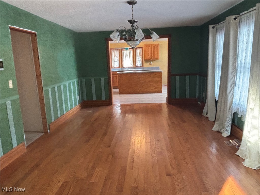 11592 Taylor Wells Road Chardon, OH 44024 - Photo 4 of 37 Unfurnished dining area with hardwood / wood-style flooring, a notable chandelier, and sink