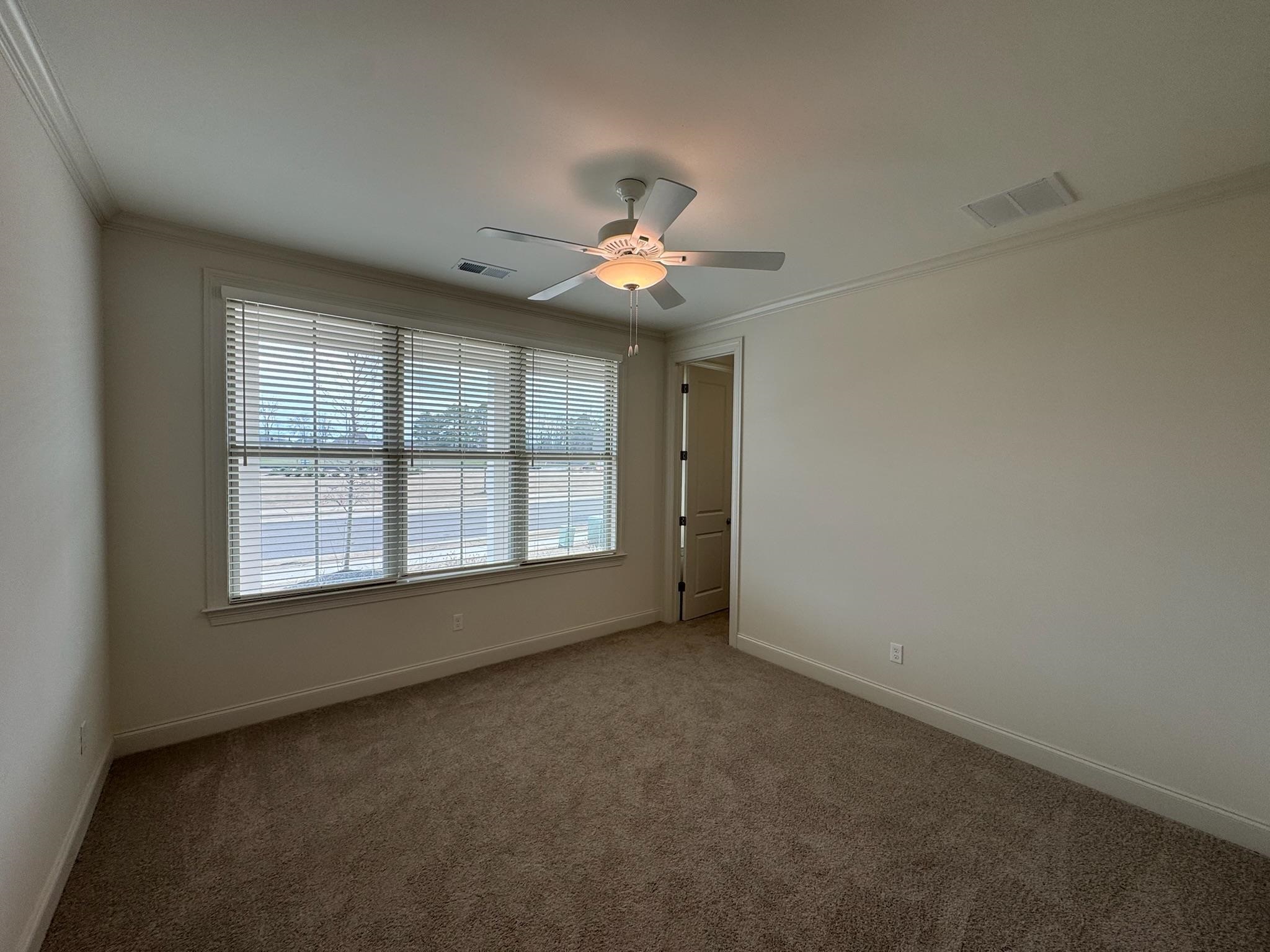 11512 Sunsparkler Way Collierville, TN 38017 - Photo 13 of 40 Carpeted spare room with crown molding and ceiling fan
