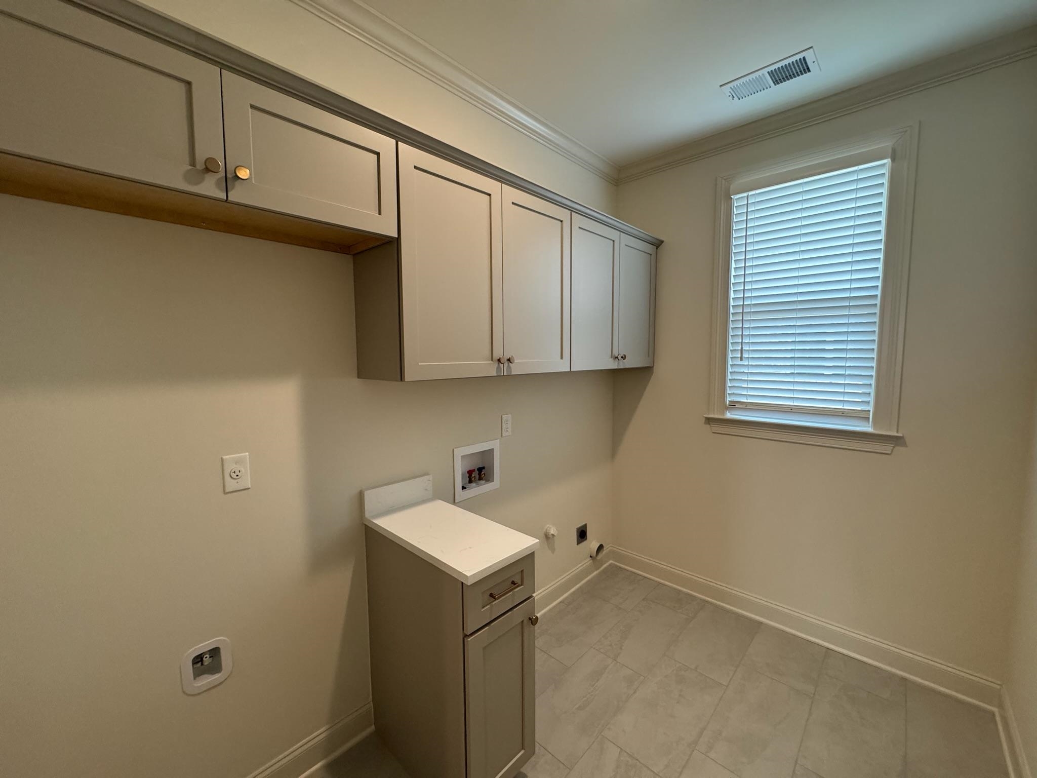 11512 Sunsparkler Way Collierville, TN 38017 - Photo 18 of 40 Laundry area with hookup for a washing machine, ornamental molding, hookup for an electric dryer, gas dryer hookup, and cabinet space