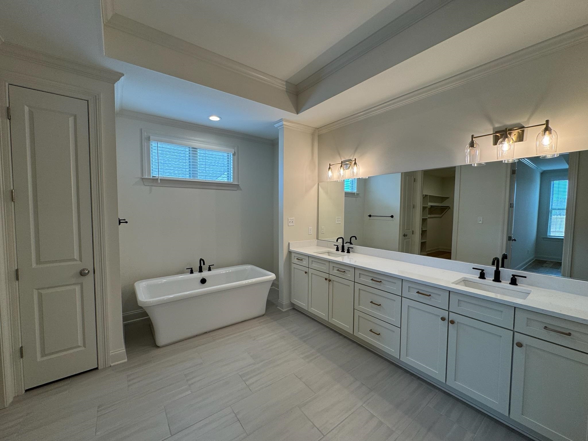 11512 Sunsparkler Way Collierville, TN 38017 - Photo 22 of 40 Bathroom featuring double vanity, ornamental molding, a freestanding tub, a spacious closet, and recessed lighting