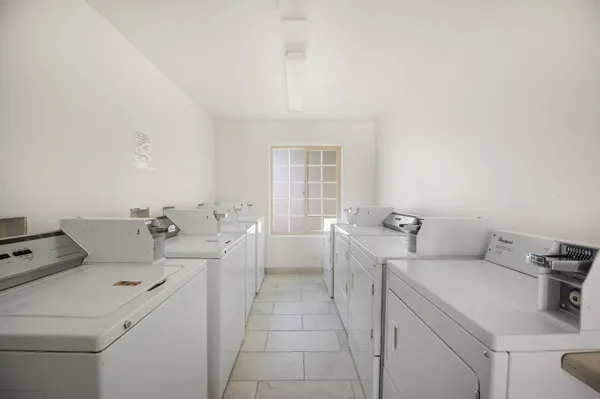 a view of washer and dryer with bathroom in the background