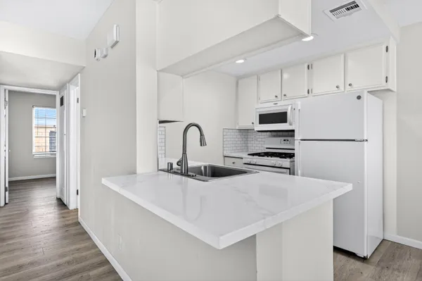 a kitchen with stainless steel appliances a refrigerator and a stove top oven