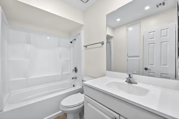 a bathroom with a sink a toilet and a large mirror