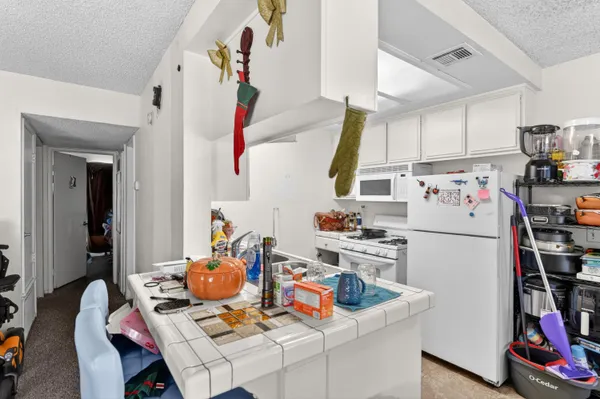 a kitchen with a refrigerator a stove and a dining table with wooden floor