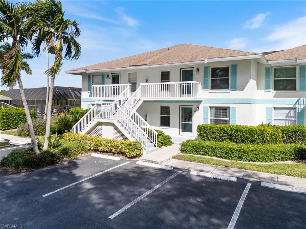 1375 Mainsail Drive, Unit 1702 Naples, FL 34114 - Photo 1 of 38 a front view of a house with a yard and potted plants