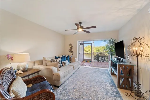 a living room with furniture a flat screen tv and a floor to ceiling window