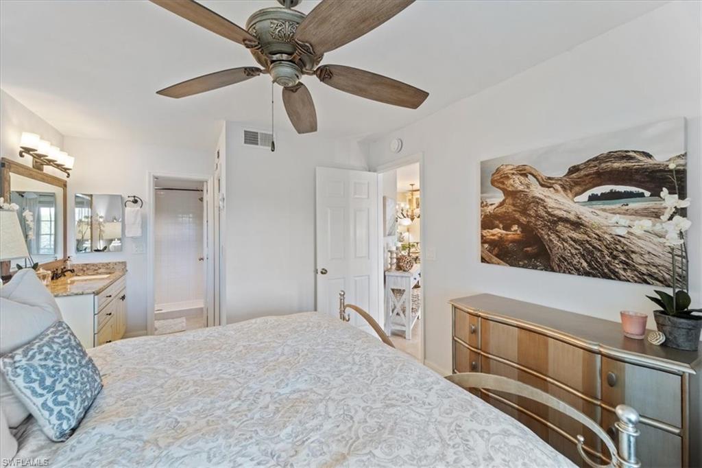 1375 Mainsail Drive, Unit 1702 Naples, FL 34114 - Photo 20 of 38 a bedroom with a bed and a chandelier