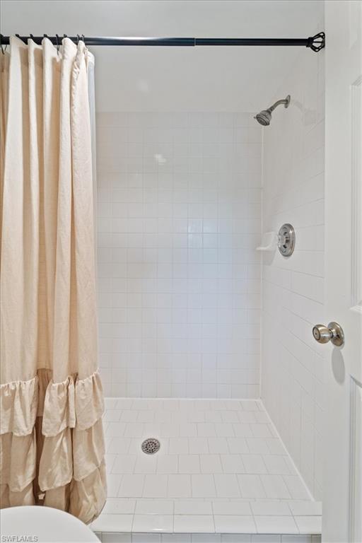 1375 Mainsail Drive, Unit 1702 Naples, FL 34114 - Photo 23 of 38 a bathroom with a shower curtain