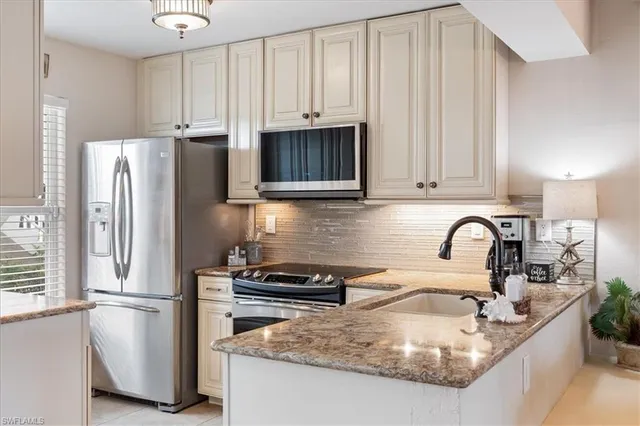 a kitchen with refrigerator a stove a sink and dishwasher with wooden floor